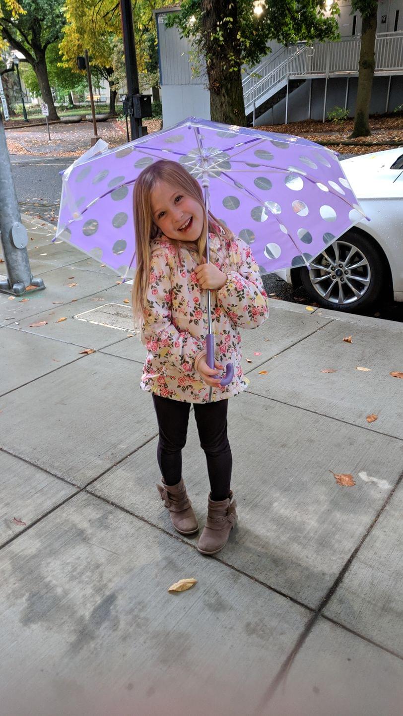 Cadence smiling with her umbrella