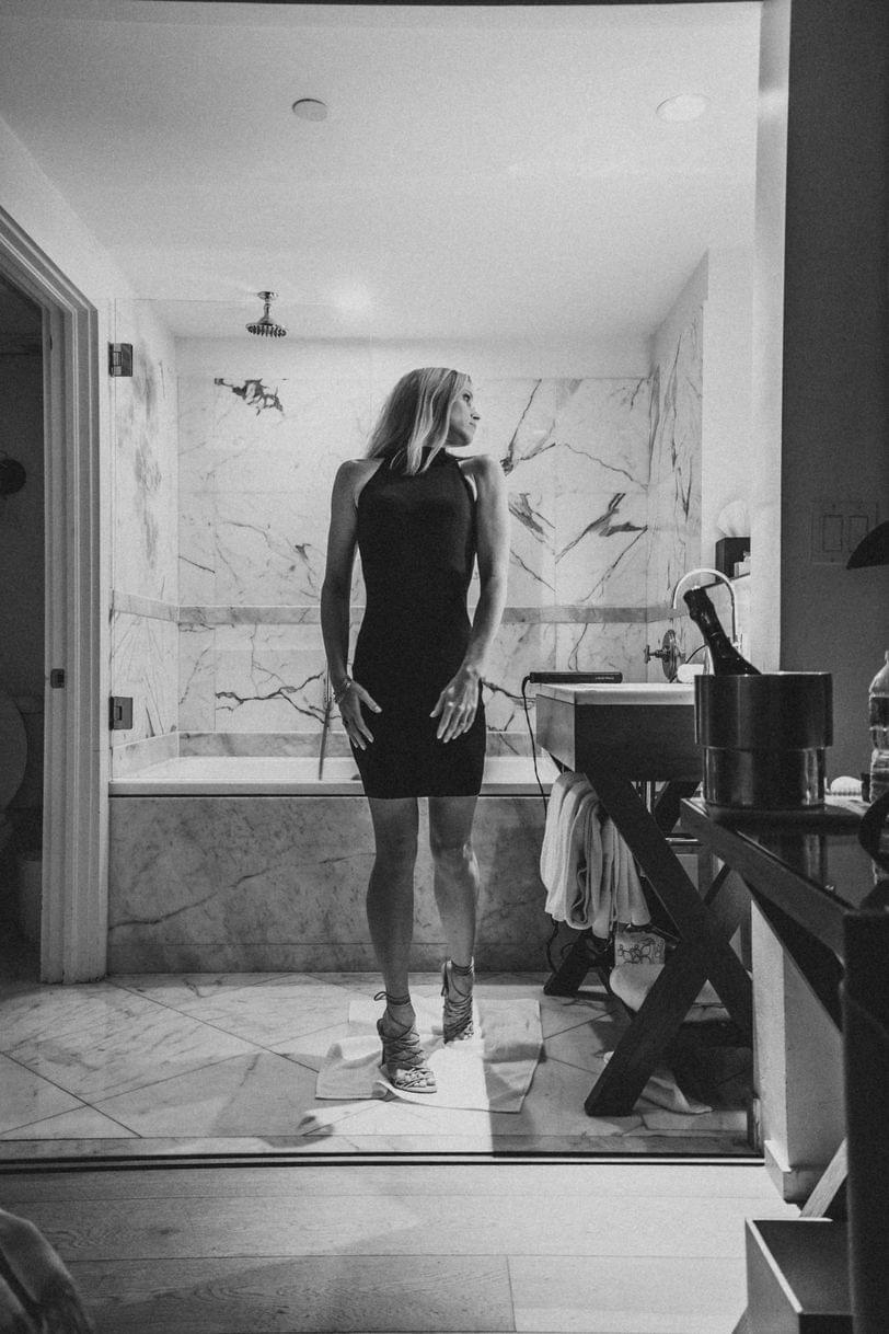 Getting ready at Hotel Victor, wearing a mini dress and strappy heels.